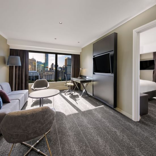 TV lounge area in Junior Suite with carpeted floors at Pullman Sydney Hyde Park