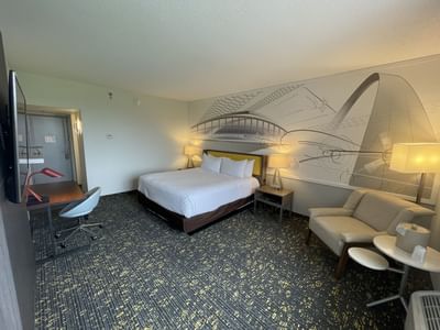 King bed, lounge area & working table in Single King Standard at St. Louis Airport Hotel