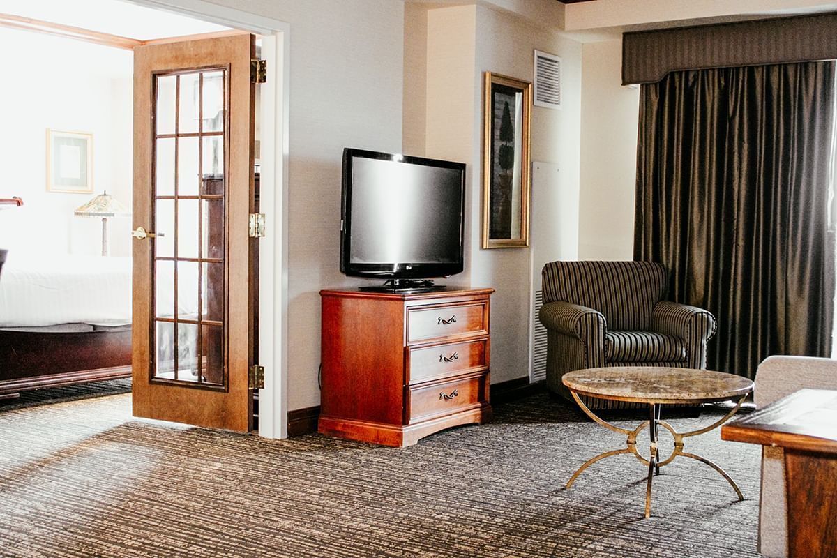 The spacious Governor Suite has an ample living space with comfortable seating, a television, and a separate king bedroom.