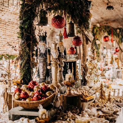 Weihnachtsmarkt-Ausstellung mit geschmückten Figuren, Girlanden, Körben voller Kugeln und dekorierten Körben.