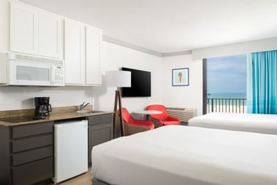 two beds facing a kitchen area