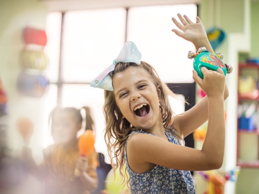 Niño feliz jugando en el club de niños en Grand Fiesta Americana