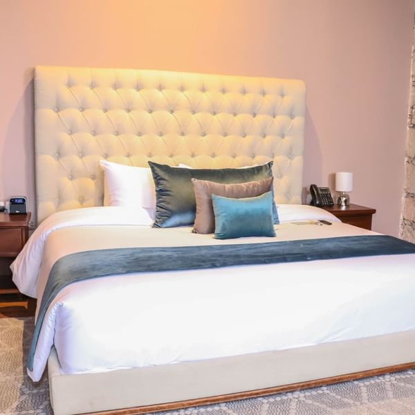 King bed with cushions in the Deluxe Room at Gamma Hotels