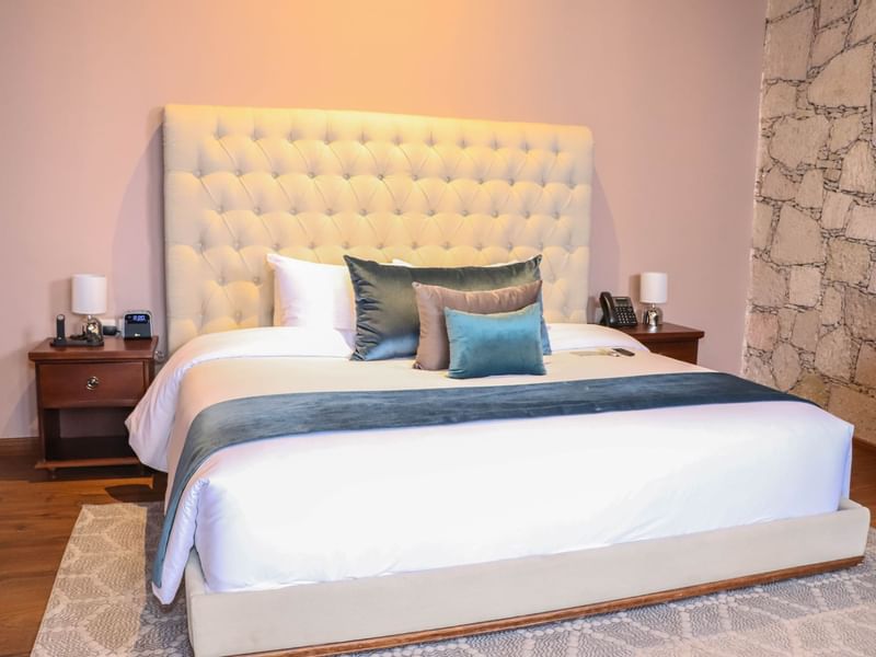 King bed with cushions in the Deluxe Room at Gamma Hotels