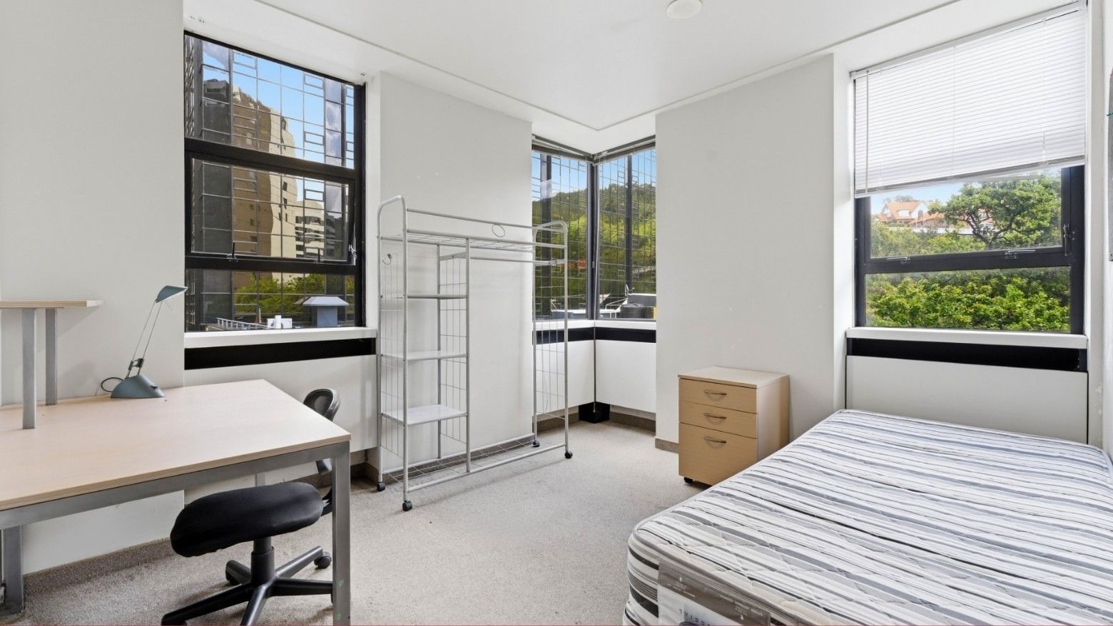 Modern room with bed, desk, chair, and window views at UniLodge Stafford House.