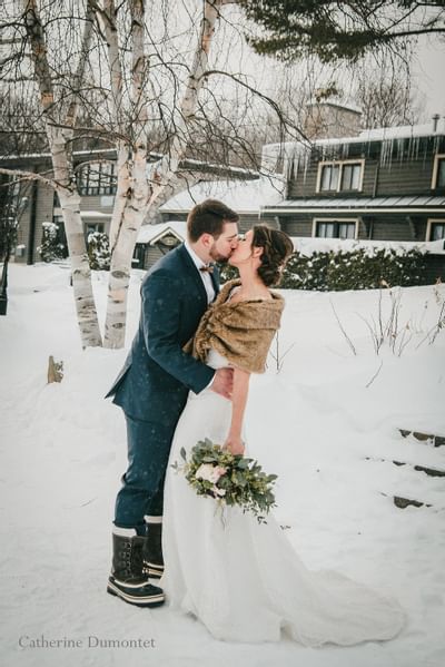 Wedded couple kissing in winter-outdoor at Hotel Mont Gabriel