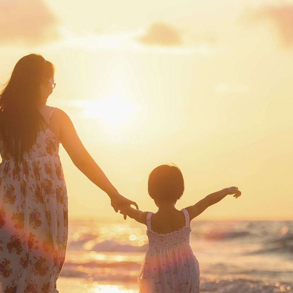 Mother & daughter strolling in the Beach at sunset near Waikiki Resort Hotel by Sono