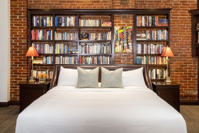 A bookshelf behind a bed in King Superior Study at Retro Suites