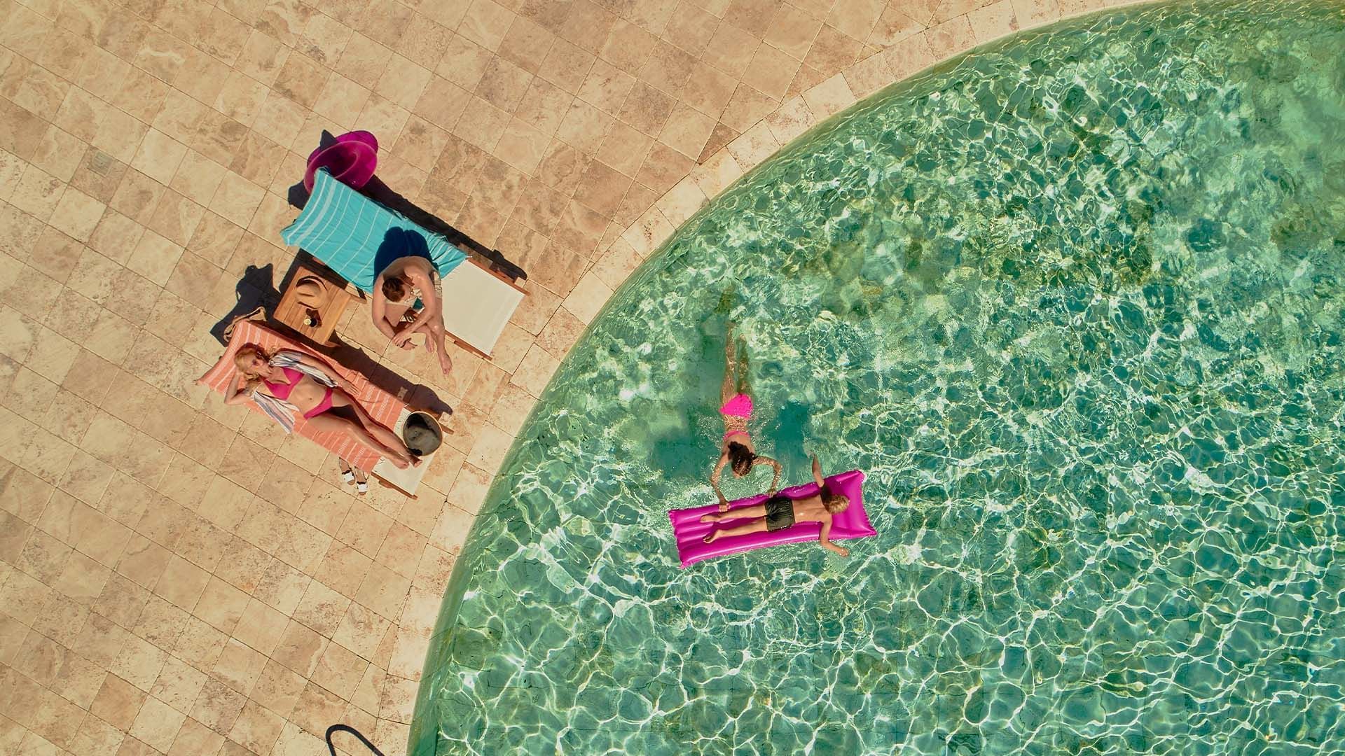Aerial view of a family by the pool at Falkensteiner Hotels