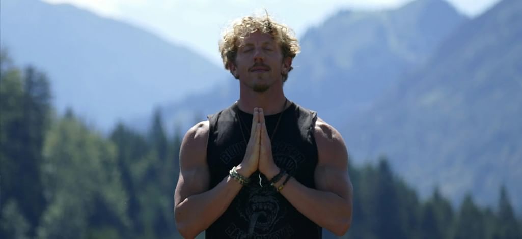 A person closes their eyes and prays on a sunny day in Canmore.