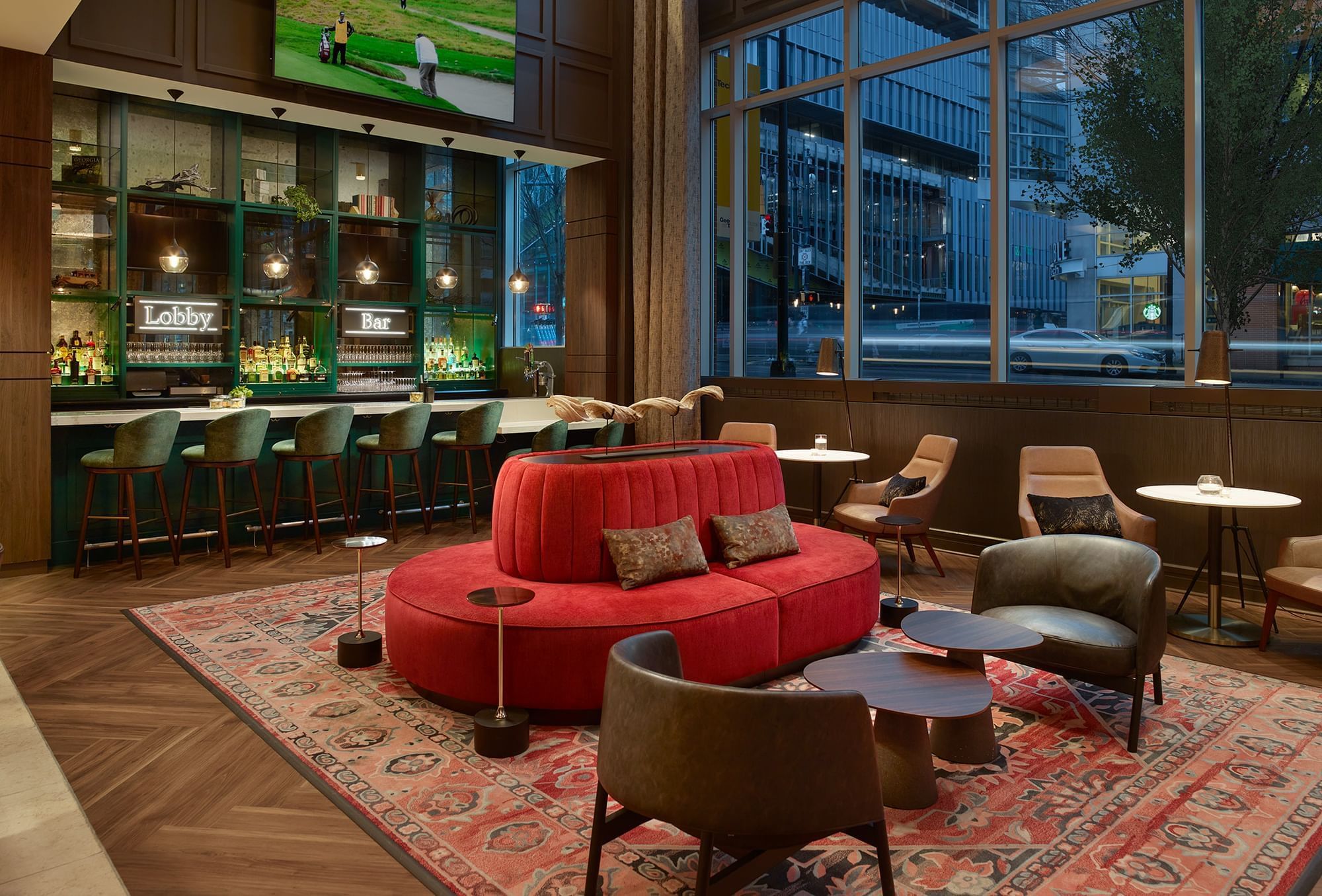 A hotel lobby with a red couch, bar, and large window