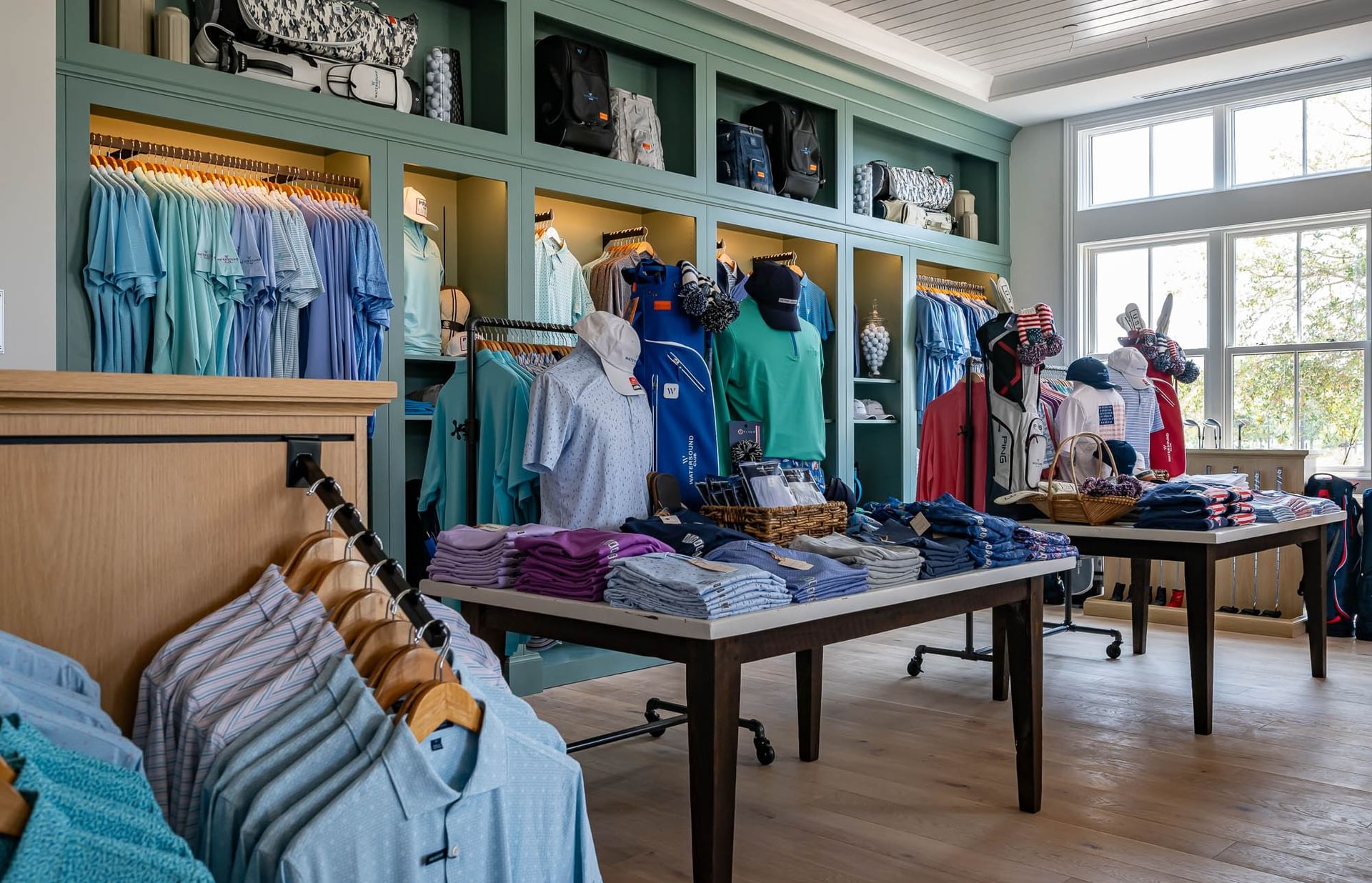 Store with shirts, caps, and golf bags displayed at the Camp Creek Golf Outfitter Shop.