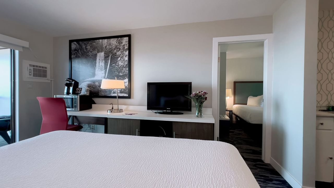 Guest room with king bed, tv, desk, chairs, balcony, ocean view