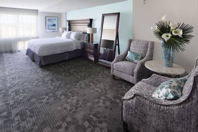 room with large bed, floor murror and two accent chairs