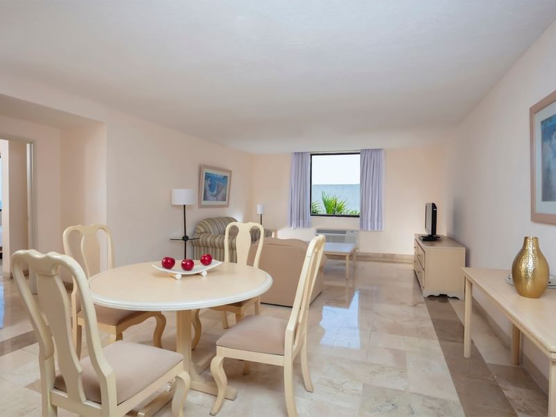 Modern living area with a round table, TV, and a chair in Premium Junior Suite at Fiesta Inn