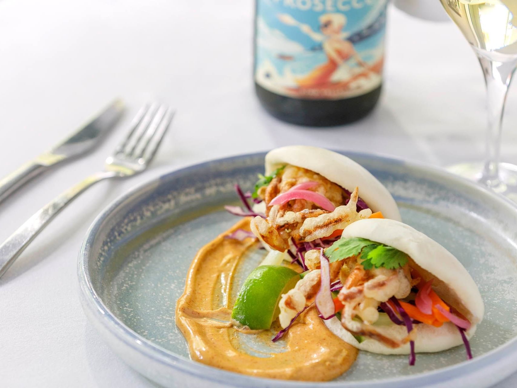 Chicken Bao Bun dish served by a wine glass at Grand Chancellor Melbourne