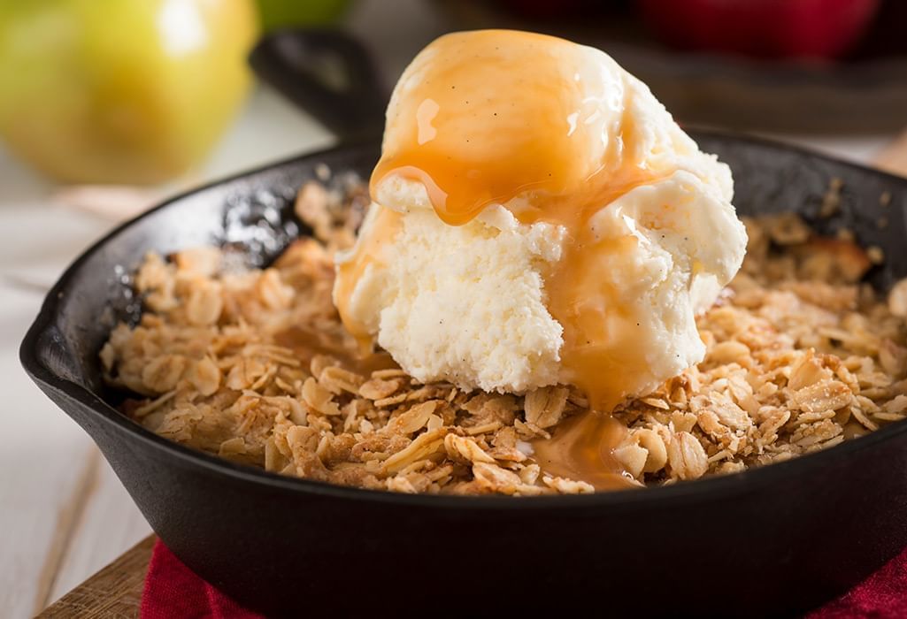 apple crisp with ice cream in a cast-iron pan