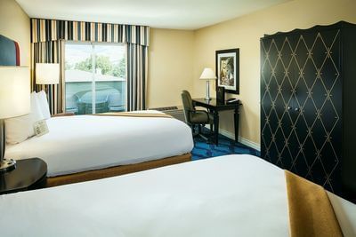 Double bed with work area in Deluxe Double Queen of Plaza Inn & Suites at Ashland Creek​