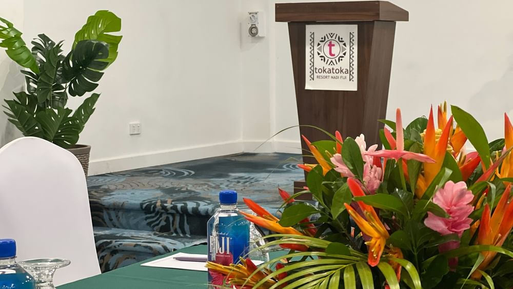 Table with bottle and flowers in Talei Meeting Room at Tokatoka Resort - Fiji International Airport, Nadi.