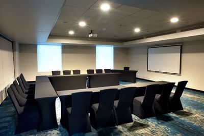 U-shape table with chairs and project screen in Aqua Room one of event space in San Jose Costa Rica at D Sabana Hotel