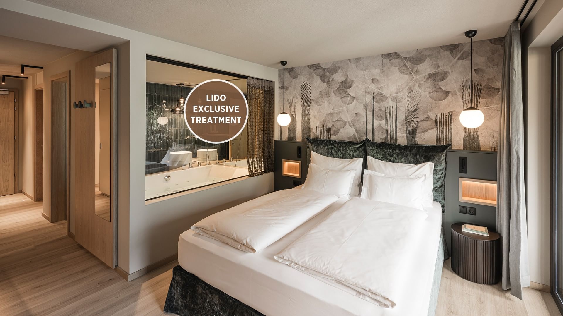 Modern hotel room with twin beds, wall-mounted lamps, and a bathroom with a large mirror.