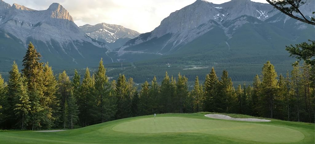 A golf course in Canmore very close to the mountains.