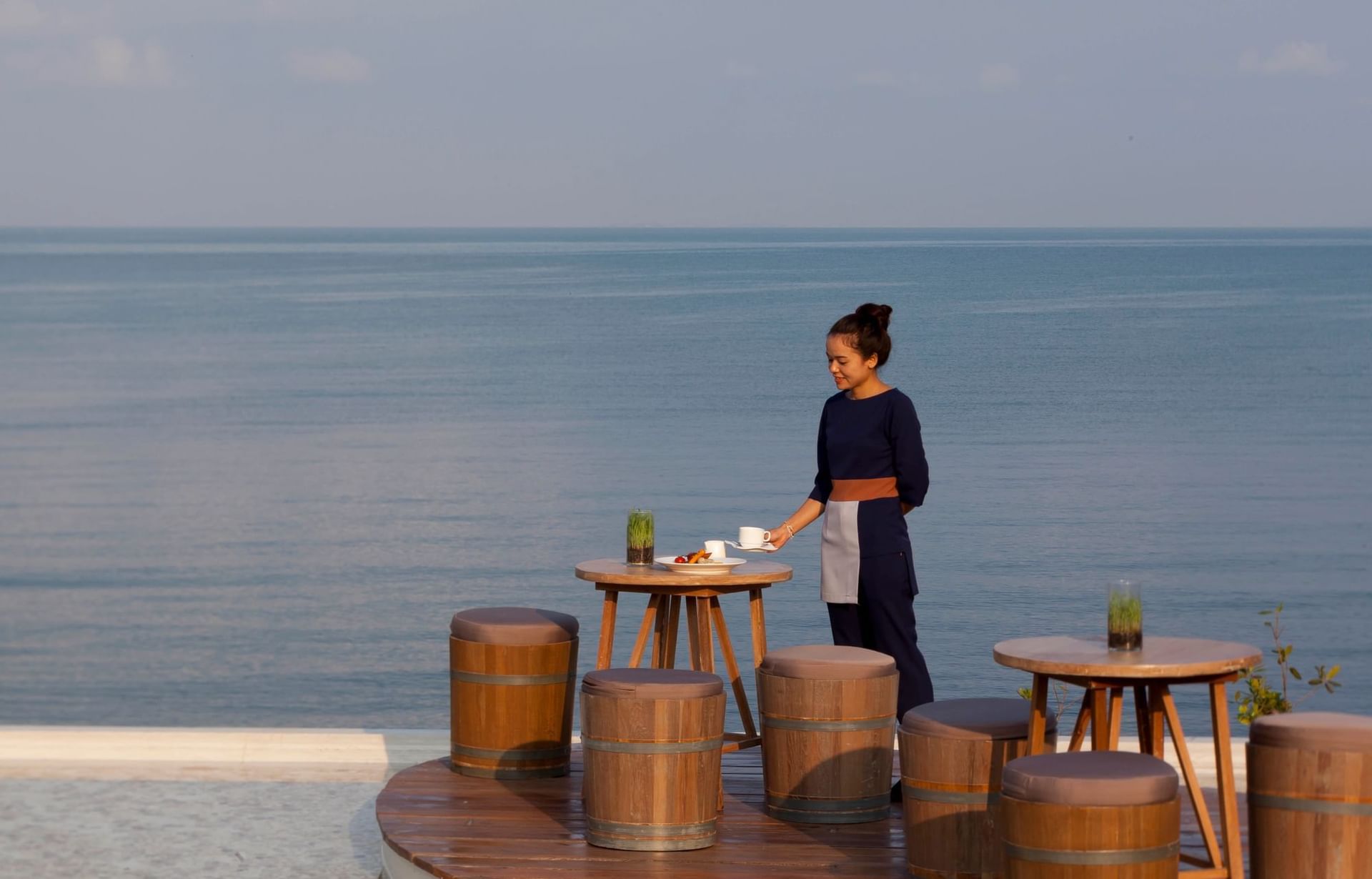 A waitress arranging tables in beach at U Hotels & Resorts