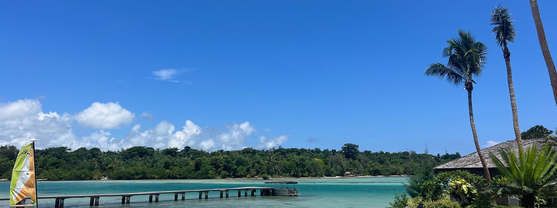 Beachfront scene with sailboats and palm trees at Warwick Le Lagon - Vanuatu in Efate