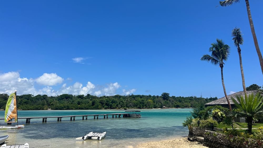 Beachfront scene with sailboats and palm trees at Warwick Le Lagon - Vanuatu in Efate.