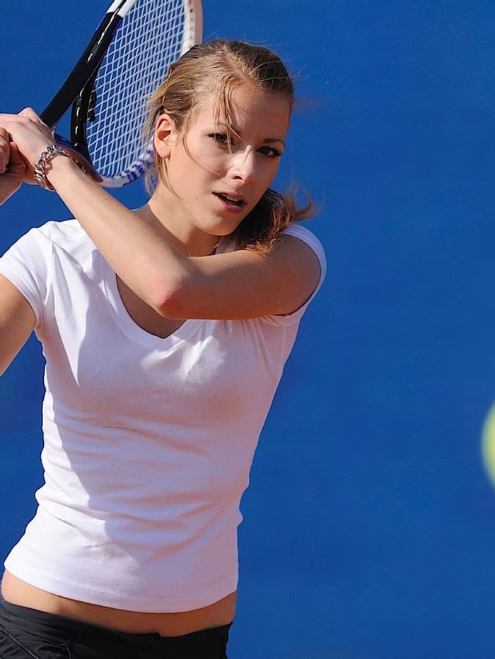 A lady playing tennis at The Pearl Hotel