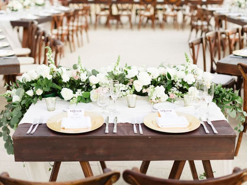 Wedding table setting with white floral centerpiece and place settings at Grand Fiesta Americana