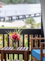 Balcony view featuring a colorful floral bouquet and a quiet dock in Garden Bungalow at warwick le lagon-vanuatu