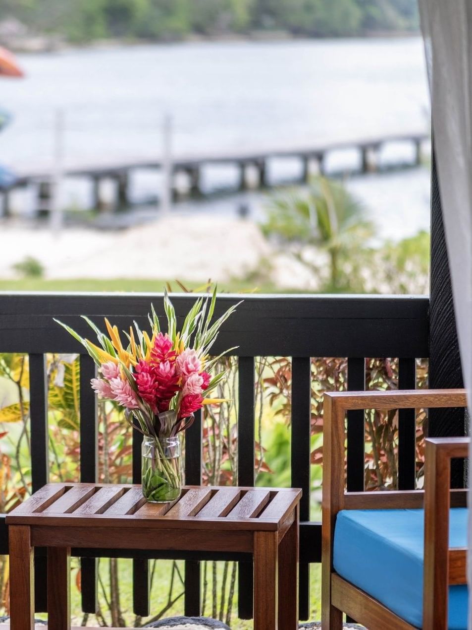 Balcony view featuring a colorful floral bouquet and a quiet dock in Garden Bungalow at warwick le lagon-vanuatu