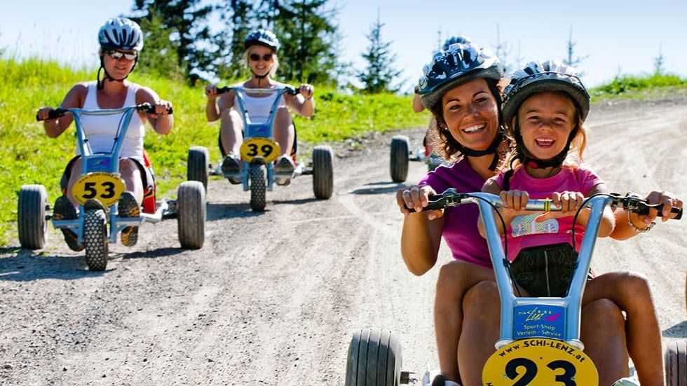 Women & kids riding mini cars near Falkensteiner Hotels