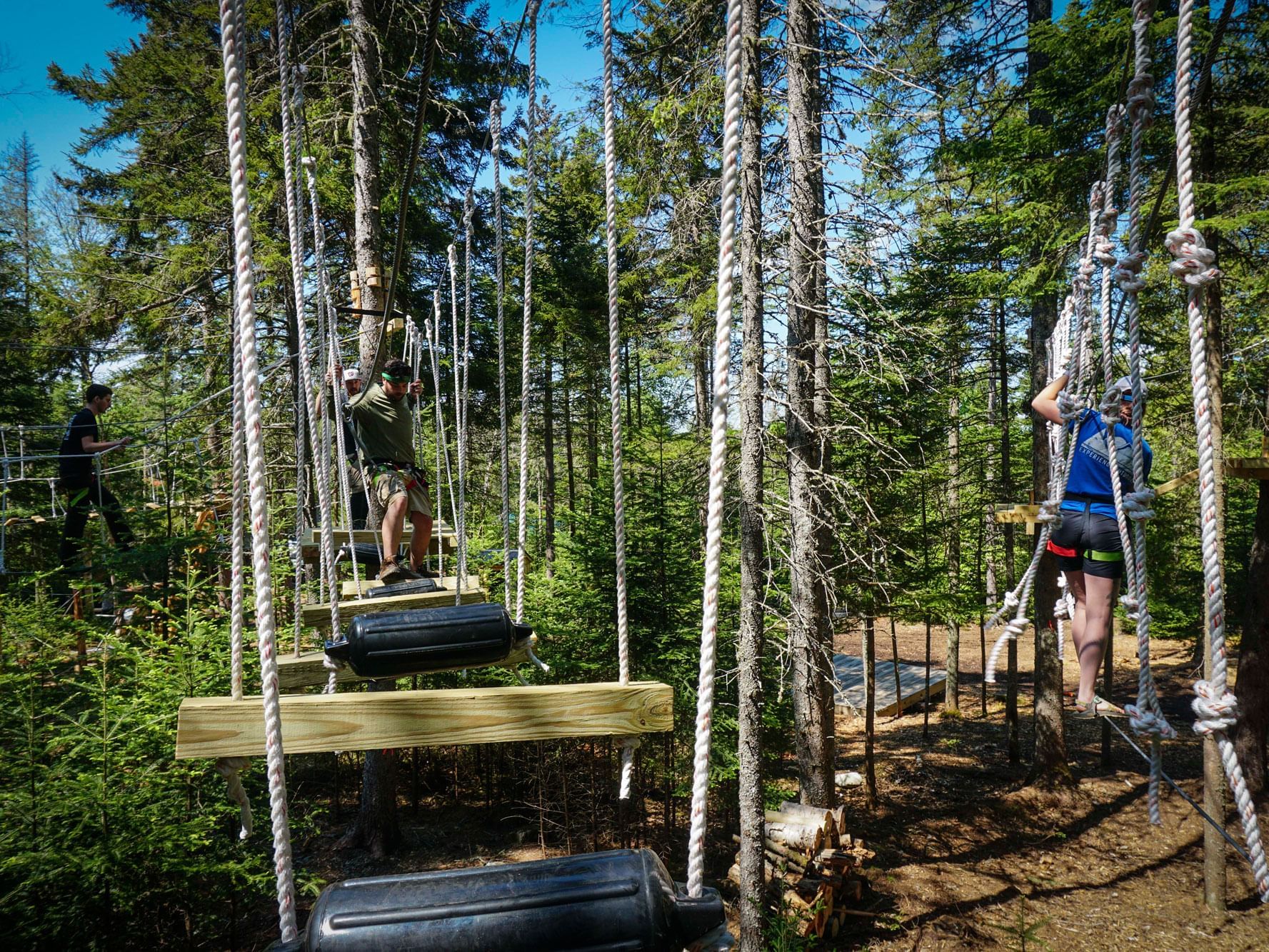 People traversing the ropes course at Experience ADK Outdoors.