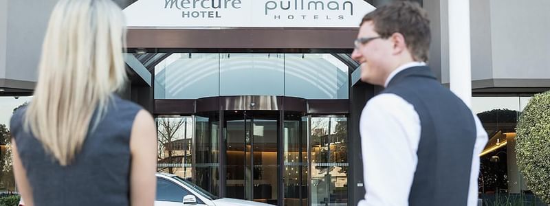 A car and a couple near the entrance of the Pullman Albert Park Hotel