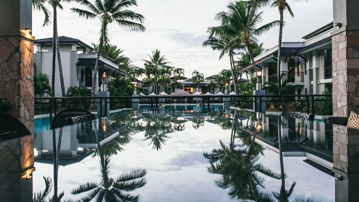 Exterior view of Pullman Port Douglas Sea Temple Resort & Spa with pool & surrounded by coconut tree