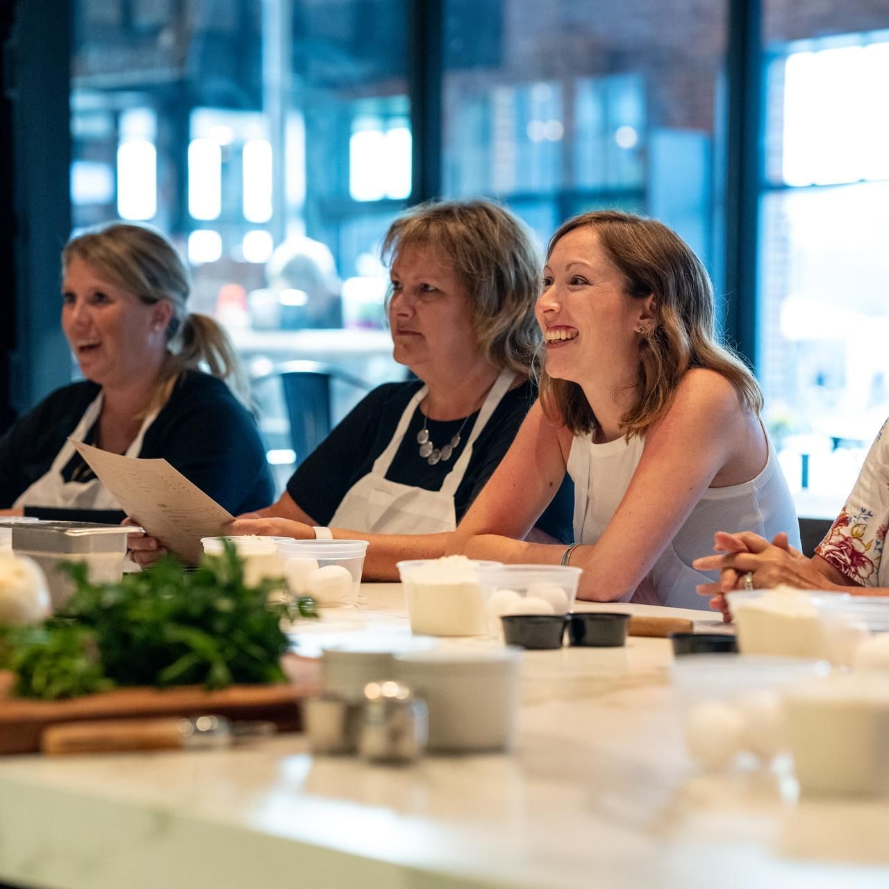 Women learning in Dave Cooking Class at The Artisan Hotel at Tuscan Village