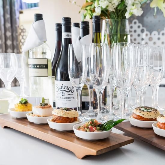 Burgers with champagne bottles and glasses aligned on a table at Pullman Albert Park