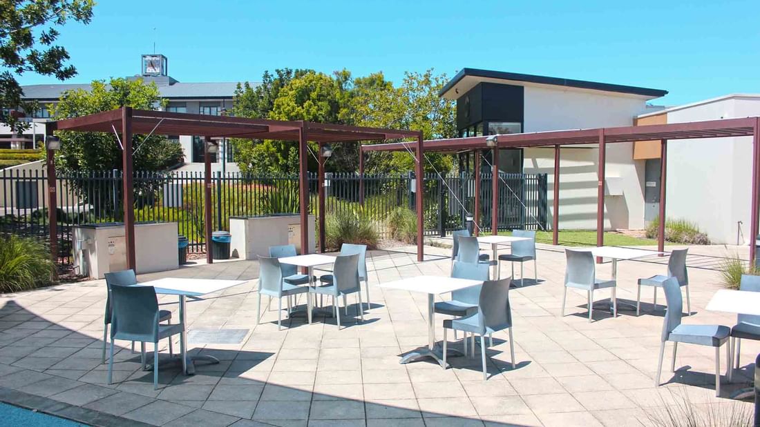 Outdoor BBQ area with tables and chairs under a pergola at Mercure Kooindah Waters