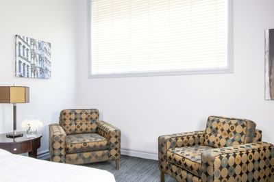 Comfy chairs by a window in King Superior Manhattan at Retro Suites Hotel