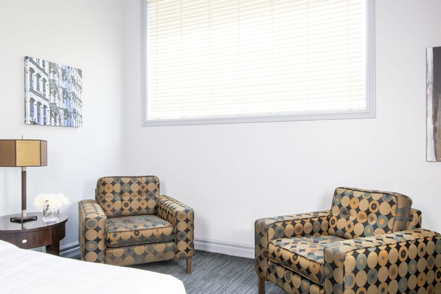 Comfy chairs by a window in King Superior Manhattan at Retro Suites Hotel