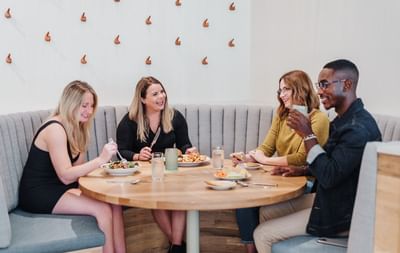 Guests enjoying their foods while smiling in Restaurant at The Stonebreaker Hotel