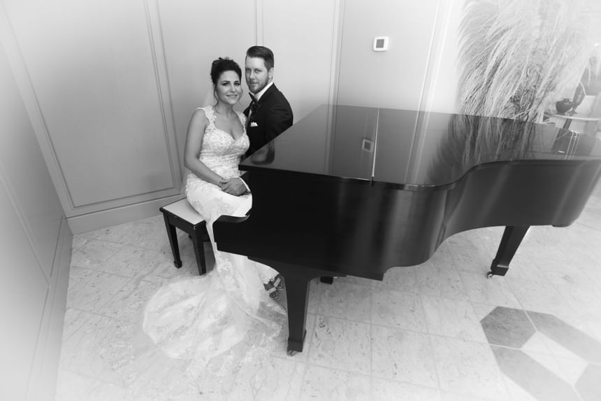 bride and groom near black piano at The Inn of Waterloo	    