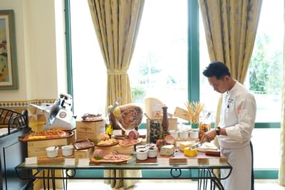 Chef arranging buffet in dining area at Hanoi Daewoo Hotel