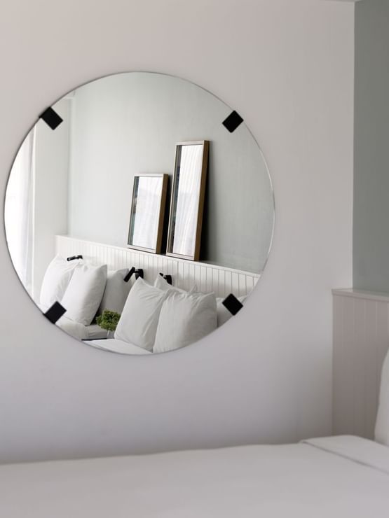 Atrium Twin reflected in a round mirror at Elysium Manly, showing two framed artworks leaning, best places to stay in Manly