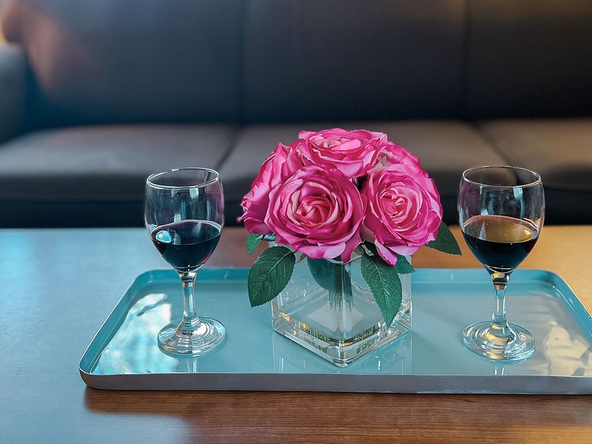 Flower and wine on a coffee table in front of a couch
