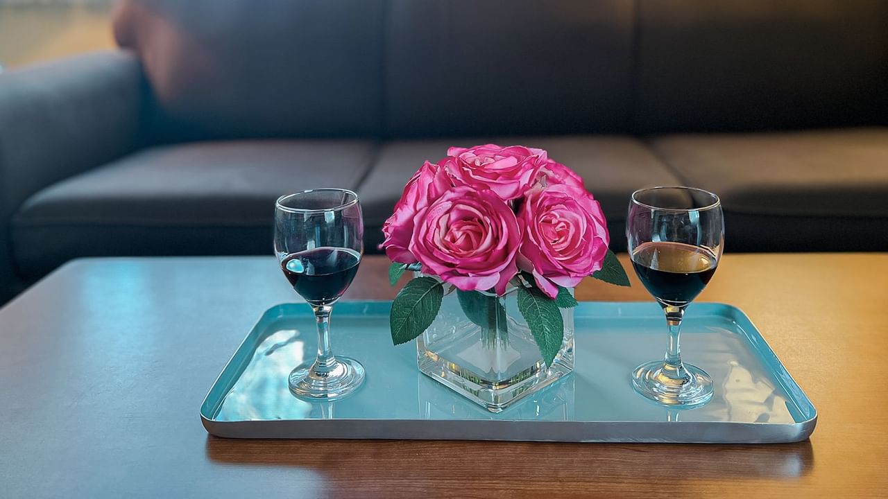 Flower and wine on a coffee table in front of a couch