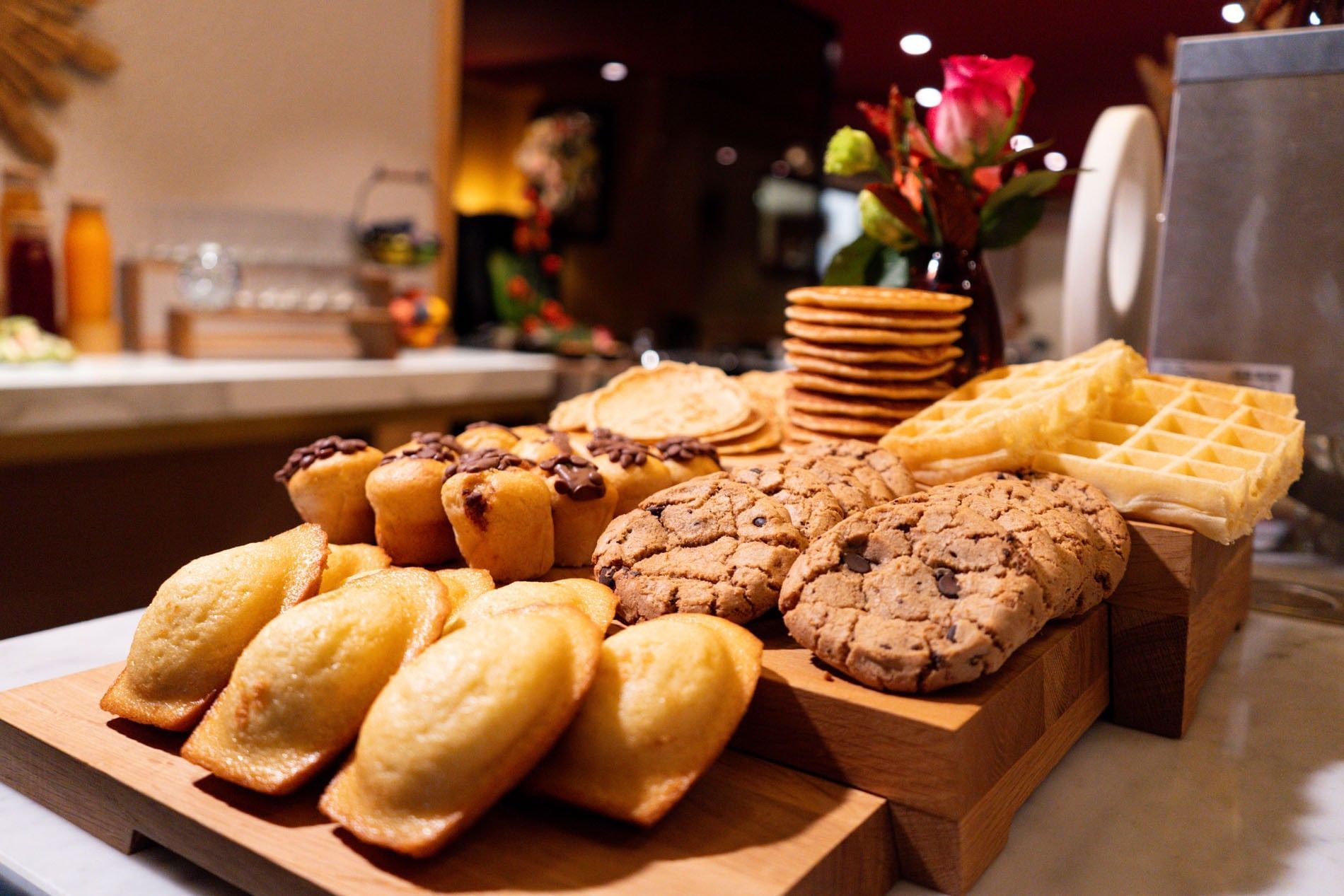 Stacks of pancakes and waffles by chocolate chip muffins and cookies in Sunday Brunch at Warwick Paris Champs Elysées