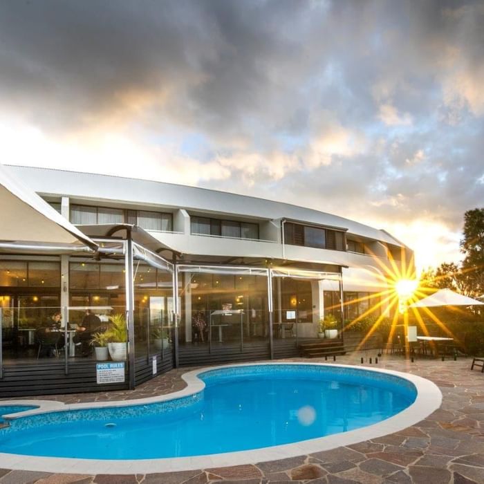 Resort pool with sun setting at Mercure Charlestown.